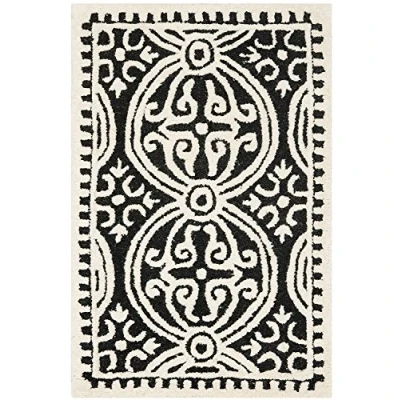 Abbildung von SAFAVIEH Traditionell Teppich für Wohnzimmer, Esszimmer, Schlafzimmer Cambridge Collection, Kurzer Flor, Schwarz und Elfenbein, 91 X 152 cm