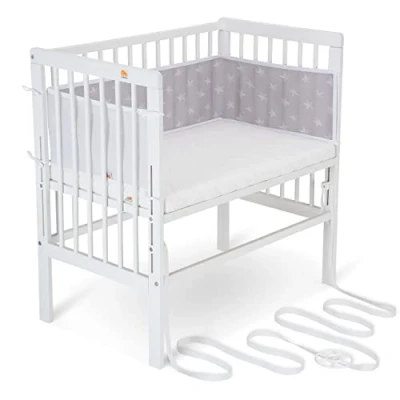 Abbildung von FabiMax Baby Beistellbett für Boxspringbett, stufenlos höhenverstellbar, Buchenholz massiv weiß lackiert, inkl. Matratze Comfort und Netz Nestchen weiße Sterne auf grau