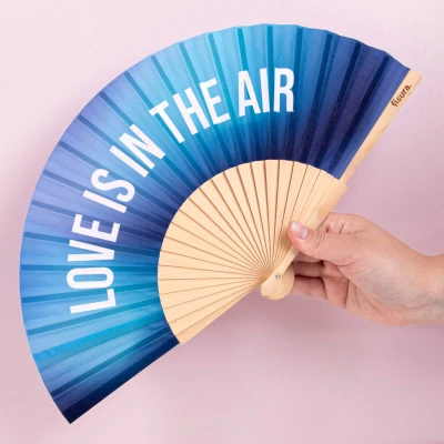 Abbildung von Fisura Handfächer aus Holz mit der Aufschrift &quot;Love is in the air“. Perfektes Accessoire für Hochzeiten, eleganter Ventilator Farbverlauf Blau und Aufhänger. Maße: 42,5 x 23 cm