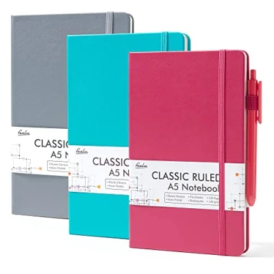 Abbildung von feela Hardcover Notizbuch für die Arbeit, klassisch, liniert, Schul und Businessbedarf, mit 3 schwarzen Stiften, 120 g/m², 13 x 21,1 cm, Stück, A5, einfarbig, Grau, Beere, Smaragd