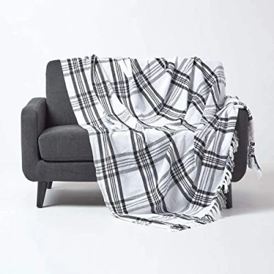 Abbildung von Homescapes Tagesdecke mit Tartan Muster, Sofa und Sessel Überwurf 150 x 200 cm Fransen, weiche Wohndecke aus 100% Baumwolle, Schottenmuster, schwarz weiß kariert