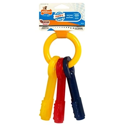 Abbildung von Nylabone, Kauspielzeug für Welpen und Zahnpflege Spielzeug zahnende Welpen, Kauspielzeug, extra kleine bis 7kg, sanft kauende/zahnende Hunde, Bacon Geschmack, Schlüsselring