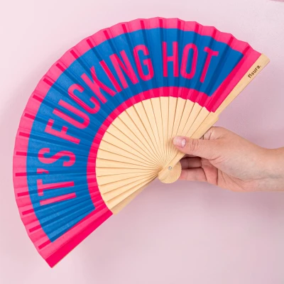 Abbildung von Fisura Handfächer aus Holz mit der Aufschrift F*cking hot“. Farbenfrohes, originelles Design in Blau und Rosa, tragbarer Ventilator Aufhänger. Perfekt für den Sommer. Maße: 42,5 x 23 cm