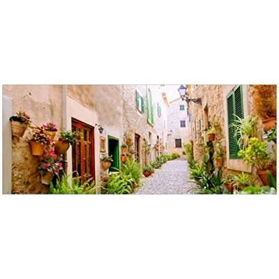 Abbildung von Wallario Glasbild Südländische Gasse mit Alten Häusern und grüner Oase 50 x 125 cm Wandbilder Glas in Premium Qualität: Brillante Farben, freischwebende Optik