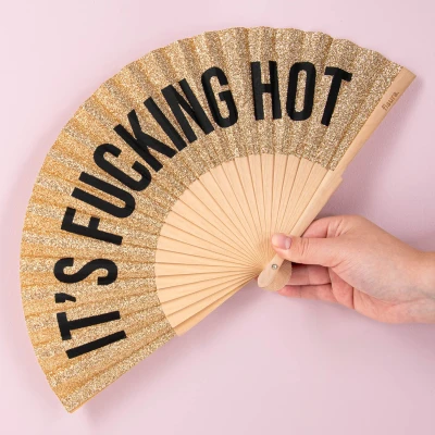Abbildung von Fisura Origineller Holzfächer mit der Aufschrift F*cking hot“. Moderner, farbenfroher Handventilator goldfarbenem Glitzereffekt. Perfektes Accessoire für heiße Tage.
