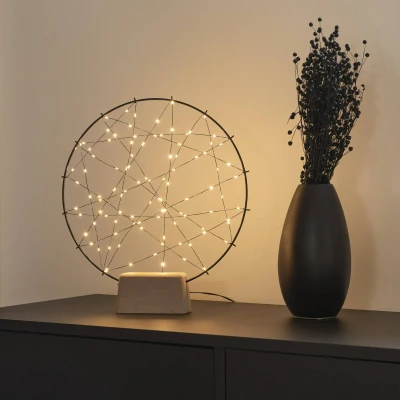 Abbildung von Konstsmide LED Metallsilhouette kleiner Ring mit Holz Fuß, schwarz, inkl. Dimmer und an/aus Schalter, schwarzem Draht, 100 bernsteinfarbene Dioden, 4, 5V Innentrafo, 2W, schwarzes Kabel 1783 787