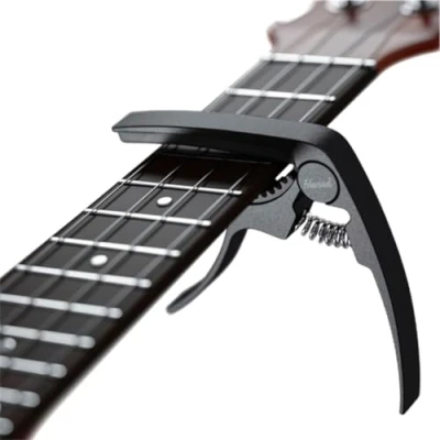 Abbildung von HAVENDI® Kapodaster für Gitarre + 3 Plektren Kinderleichte Bedienung Capo Westerngitarre, Akustikgitarre, Konzertgitarre, E &amp; Ukulele